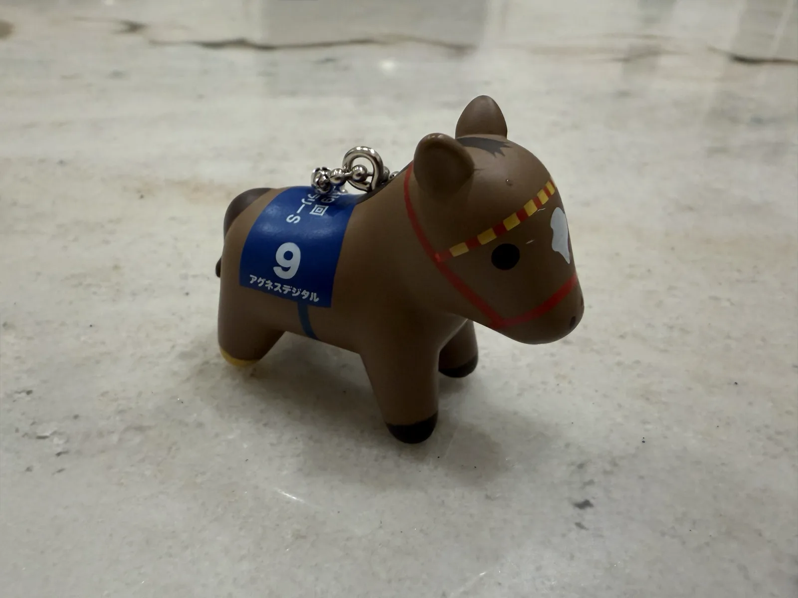 The actual DonkeyMooMoo: a small brown gashapon racehorse figurine that genuinely looks like a horse and a cow had a child.
